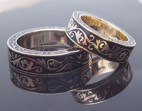 Two 18K gold bands with black enamel